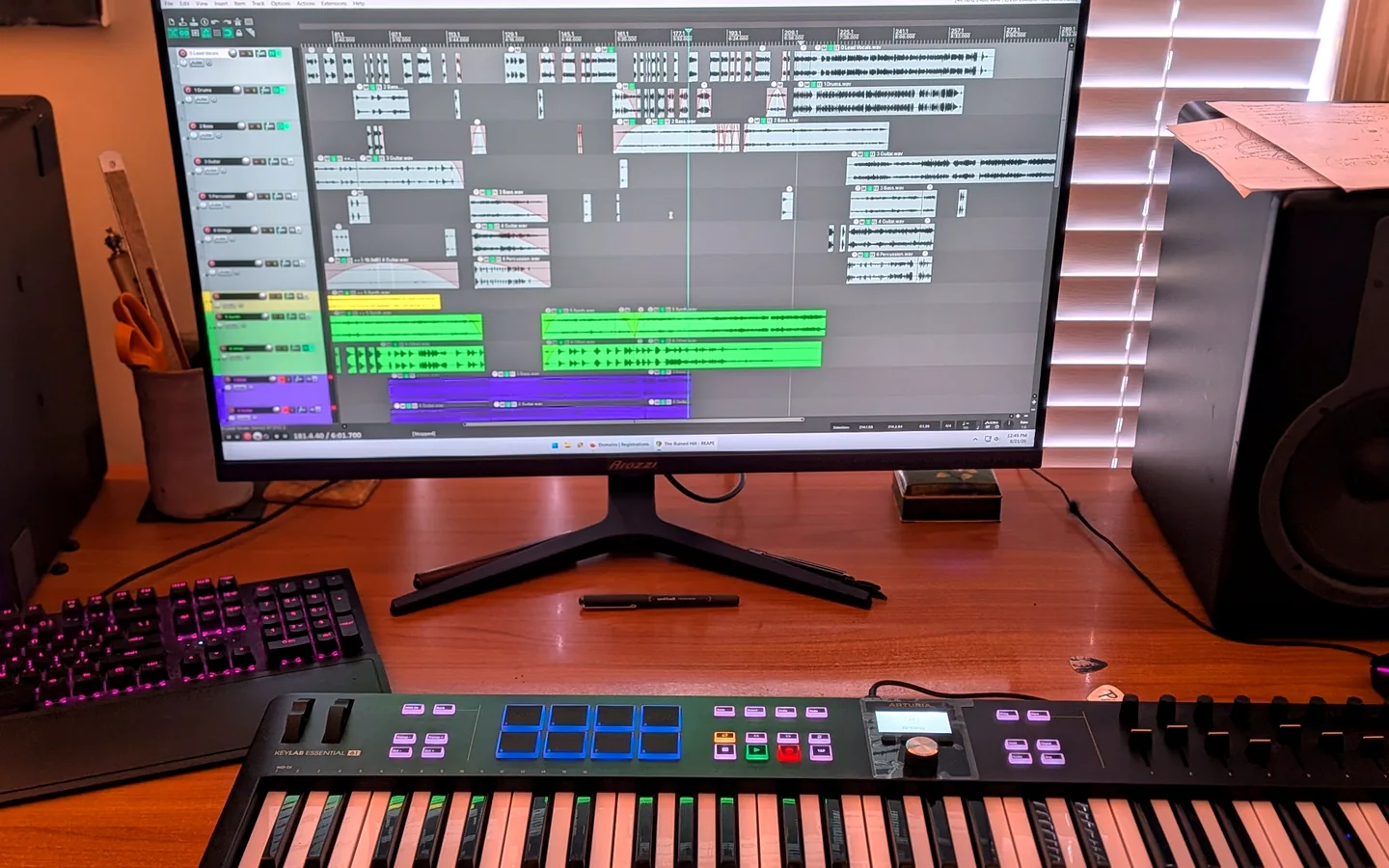 Music production workstation showing multitrack arrangement and MIDI keyboard controller